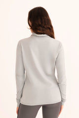 Woman wearing a light blue turtleneck sweater on a white background