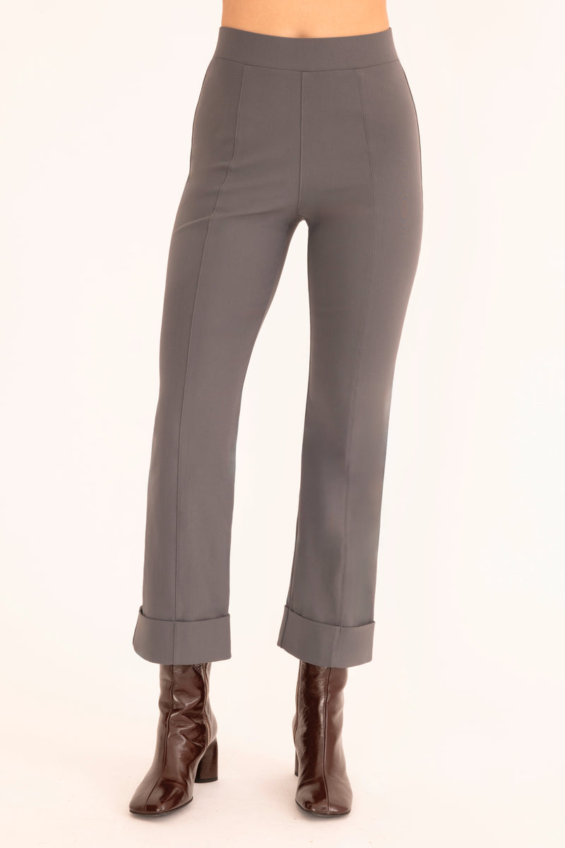 Gray pants worn with brown boots on a white background