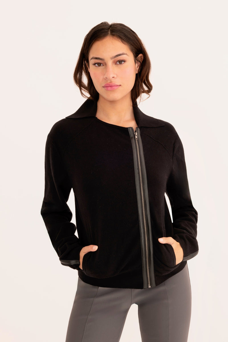 Woman wearing a black moto sweater on a white background