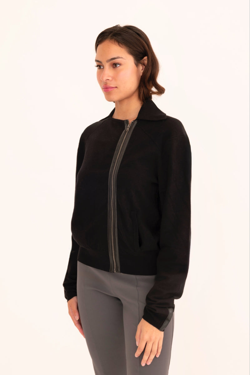 Woman wearing a black moto sweater on a white background
