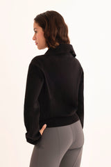 Woman wearing a black moto sweater on a white background