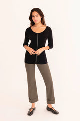 Woman wearing a black top and gray pants on a white background