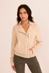 Woman wearing a light beige moto sweater on a white background
