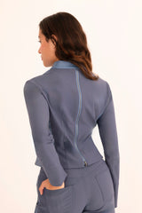 Woman wearing a blue suit with a zipper detail on a white background