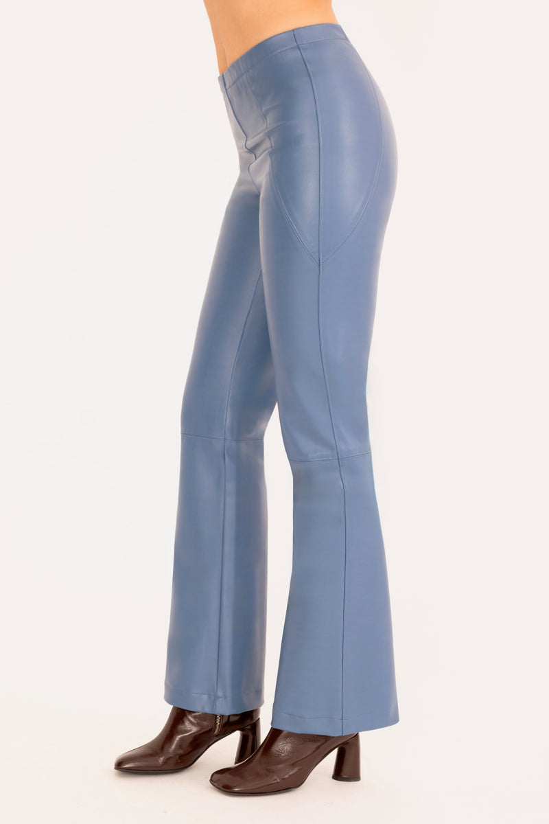 Blue flared pants worn by a person on a white background