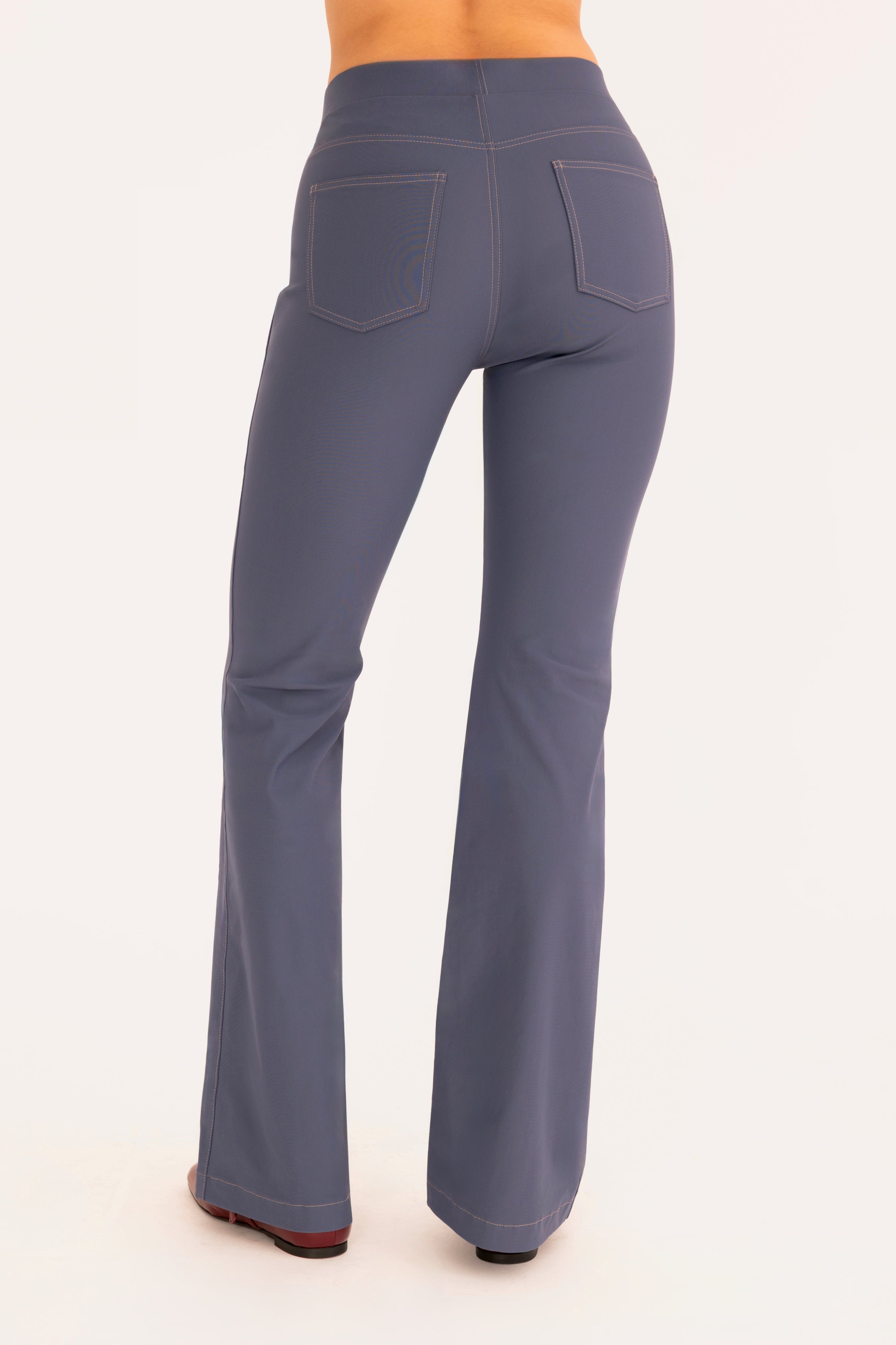 Back view of blue flare jean pants on a white background