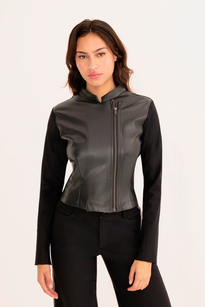 Woman wearing a black leather jacket and pants on a white background