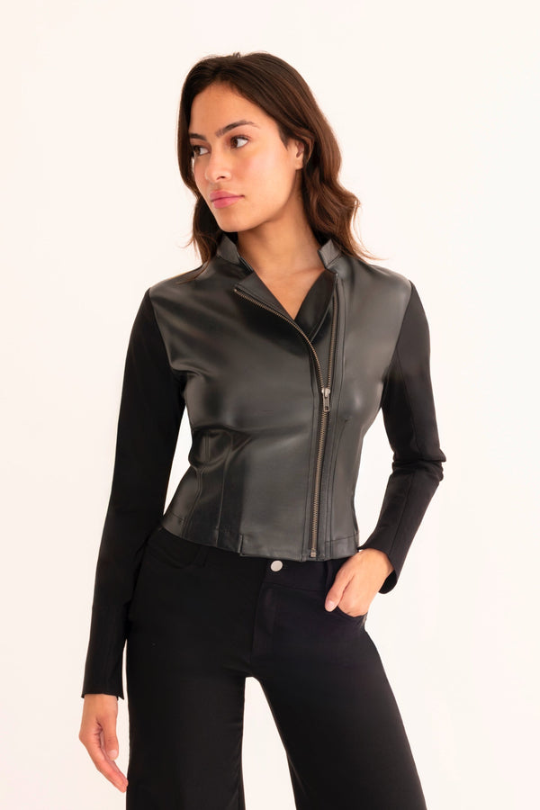 Woman wearing a black leather jacket and black pants on a white background