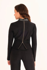 Woman wearing a black outfit with a zipper detail on a white background