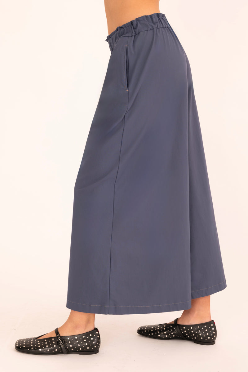 Blue wide-leg pants worn by a person on a beige background