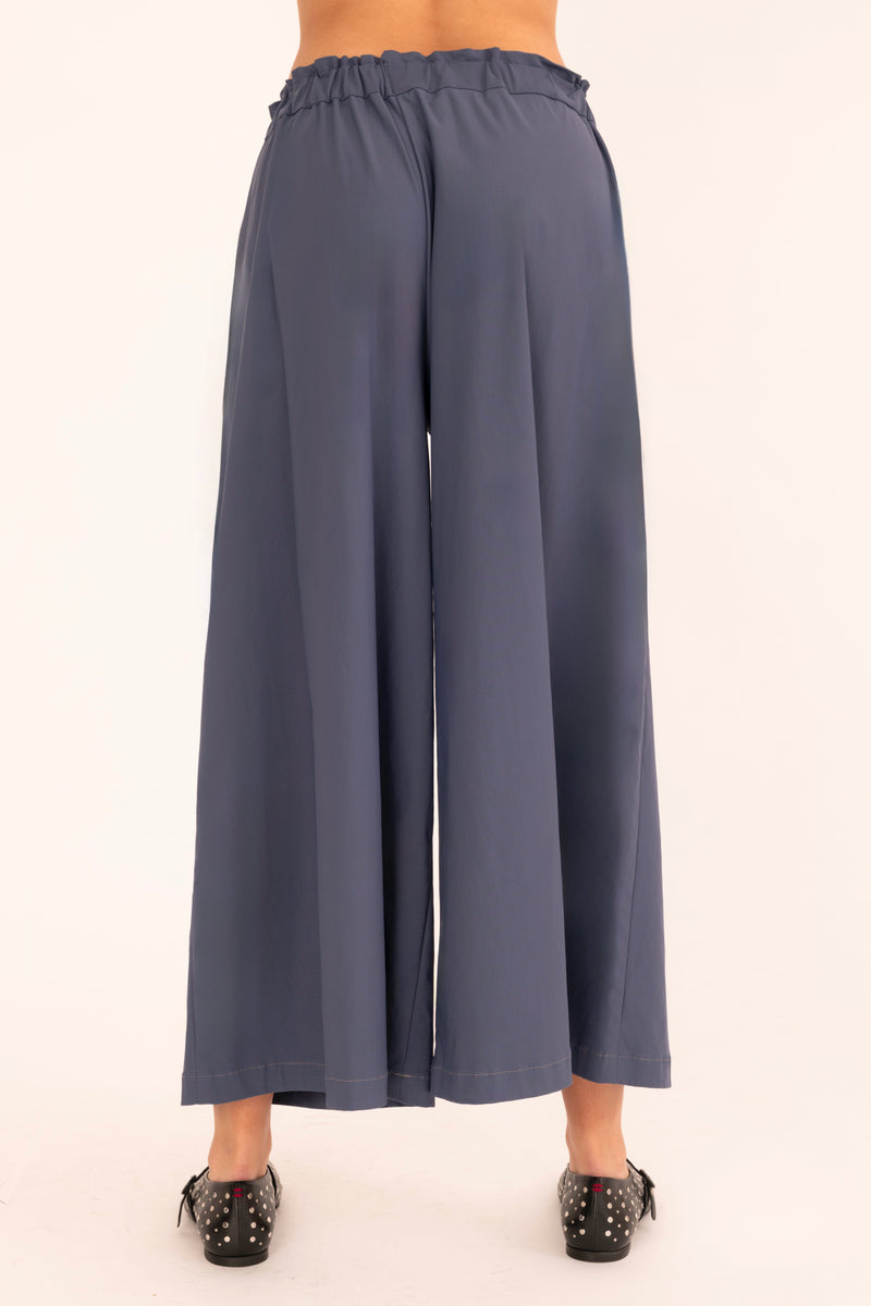 Blue wide-leg pants worn by a person on a white background