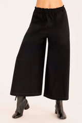 Black wide-leg pants worn by a person on a white background