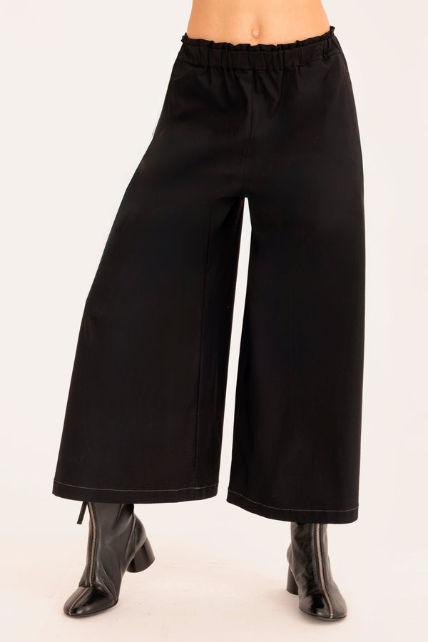 Black wide-leg pants worn by a person on a white background
