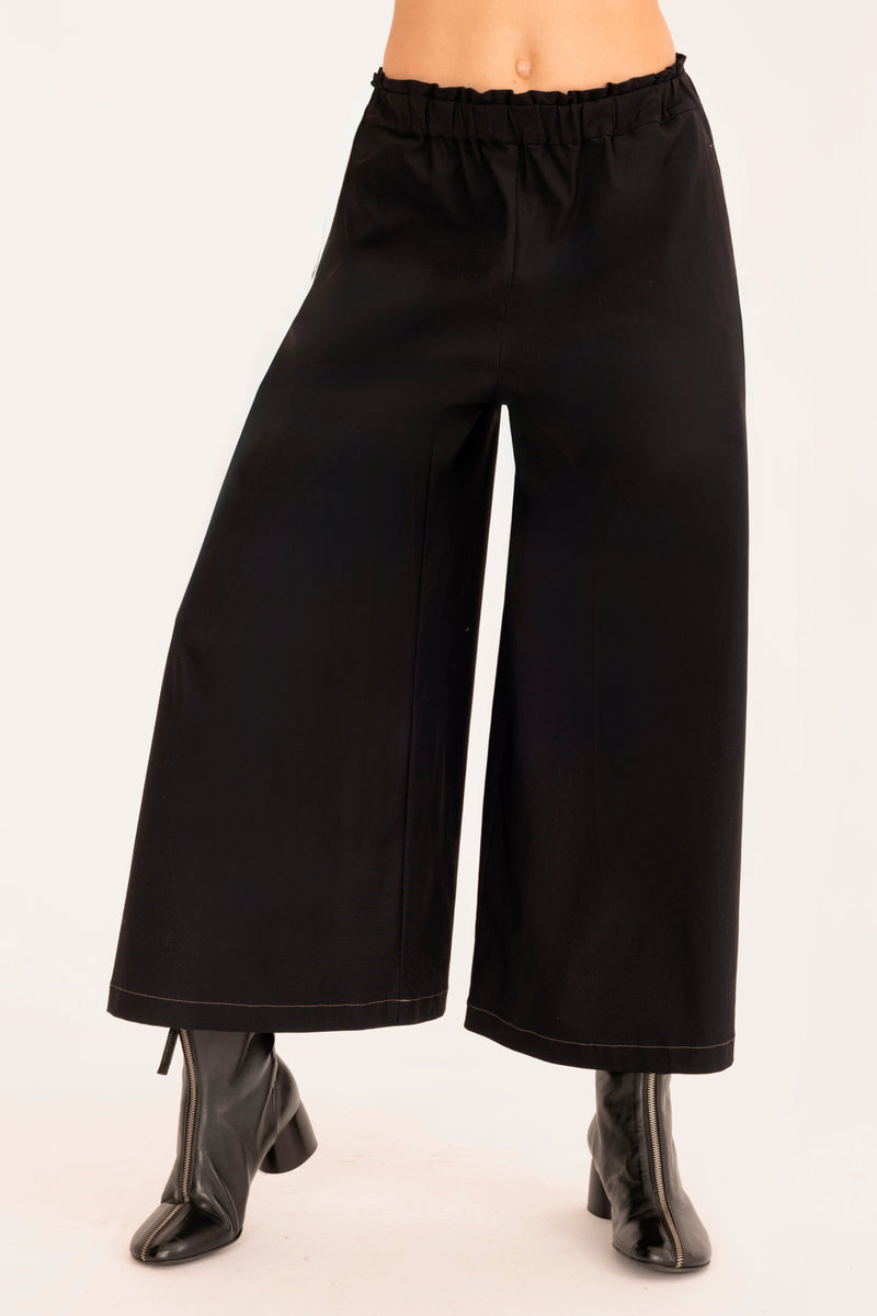 Black wide-leg pants worn by a person on a white background