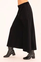 Black pant worn by a person on a white background