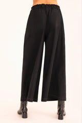 Black wide-leg pants worn by a person on a white background