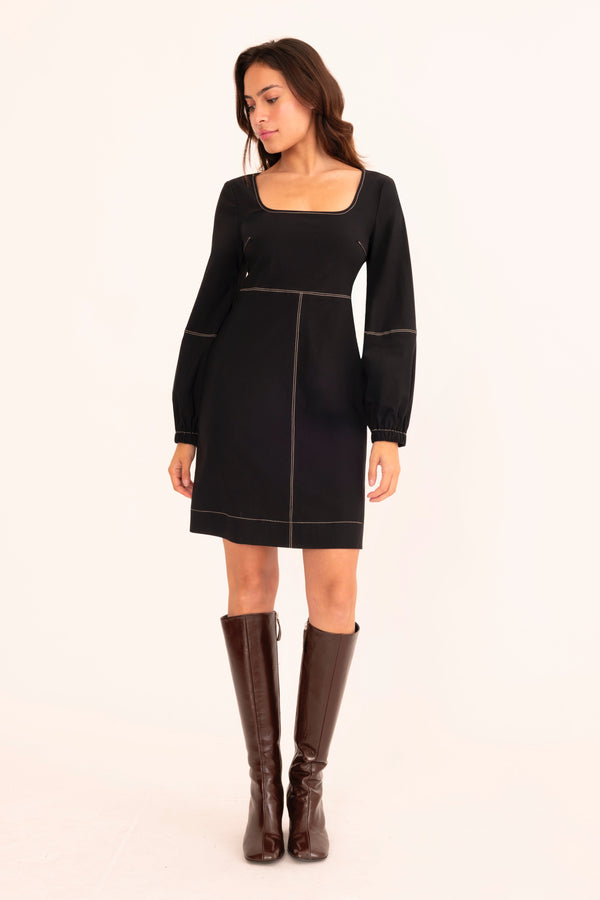 Woman wearing a black dress with a plain background