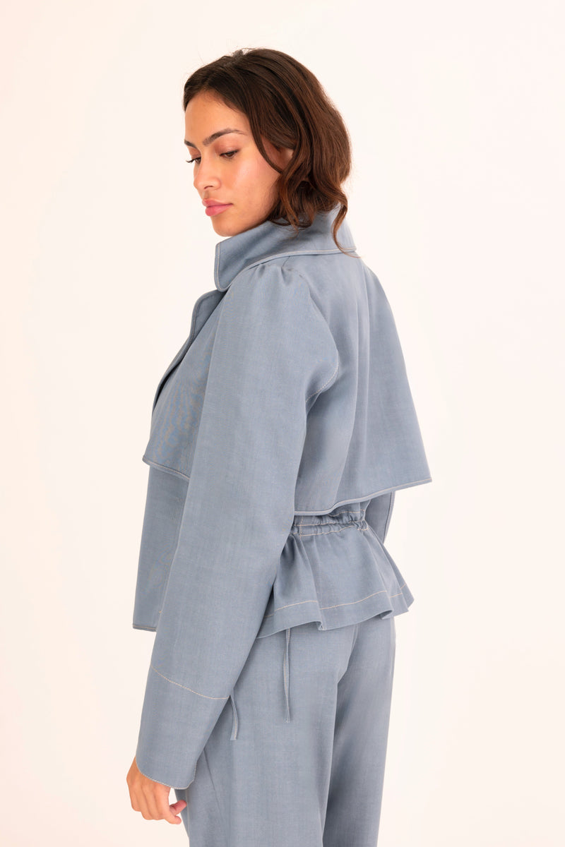 Woman wearing a light blue outfit on a white background