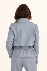 Person wearing a light gray outfit on a white background