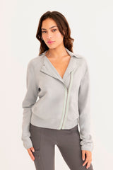Woman wearing a light blue moto sweater on a white background