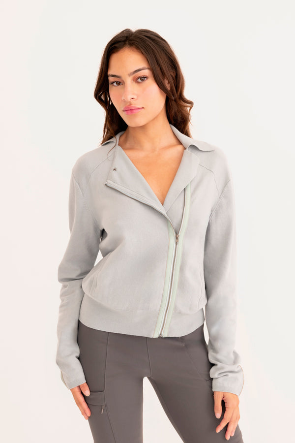 Woman wearing a light blue moto sweater on a white background
