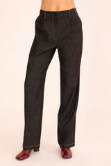 Black pants worn by a person on a beige background