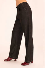 Dark denim wide-leg pants worn by a person on a beige background