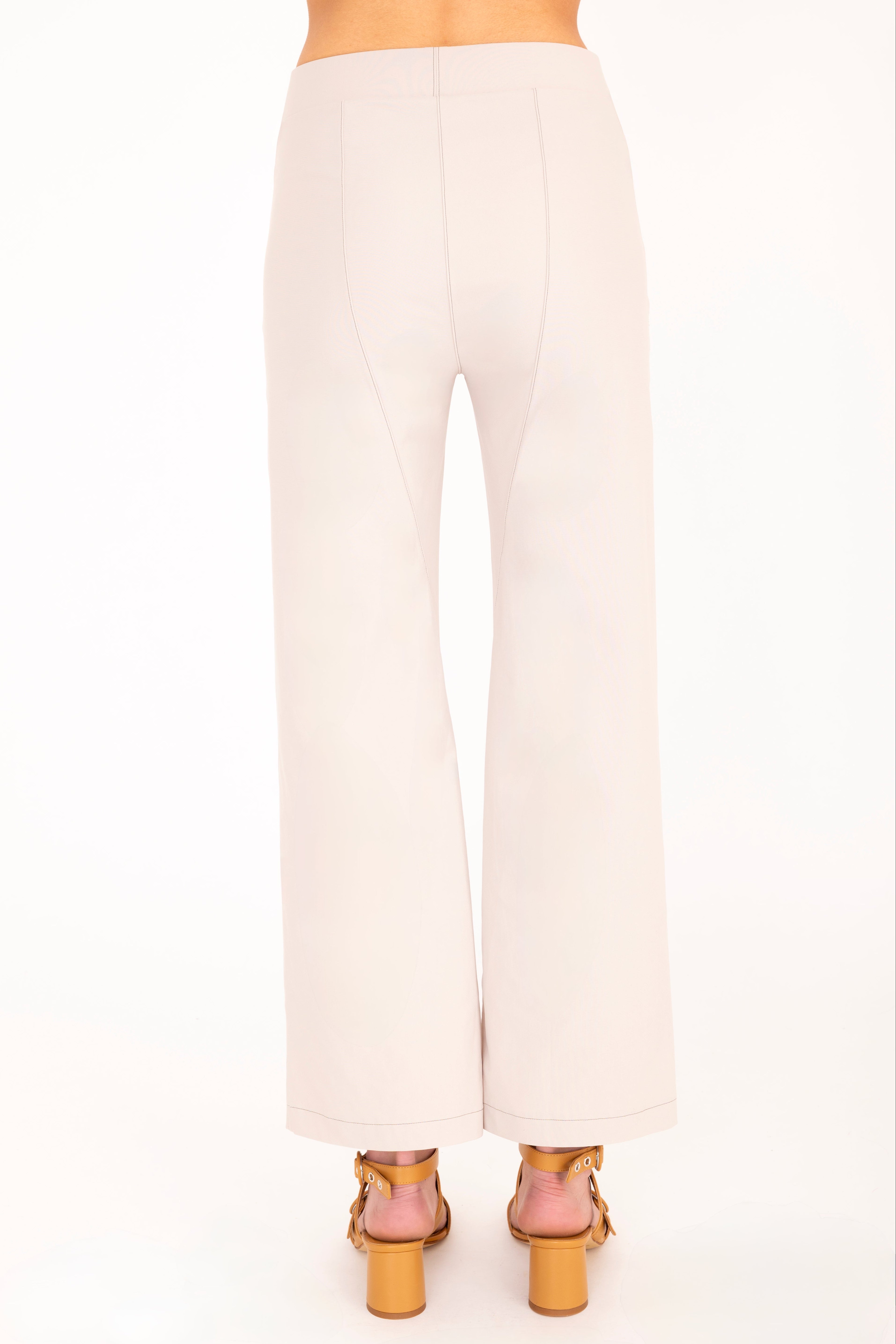 Beige pants worn by a person on a white background