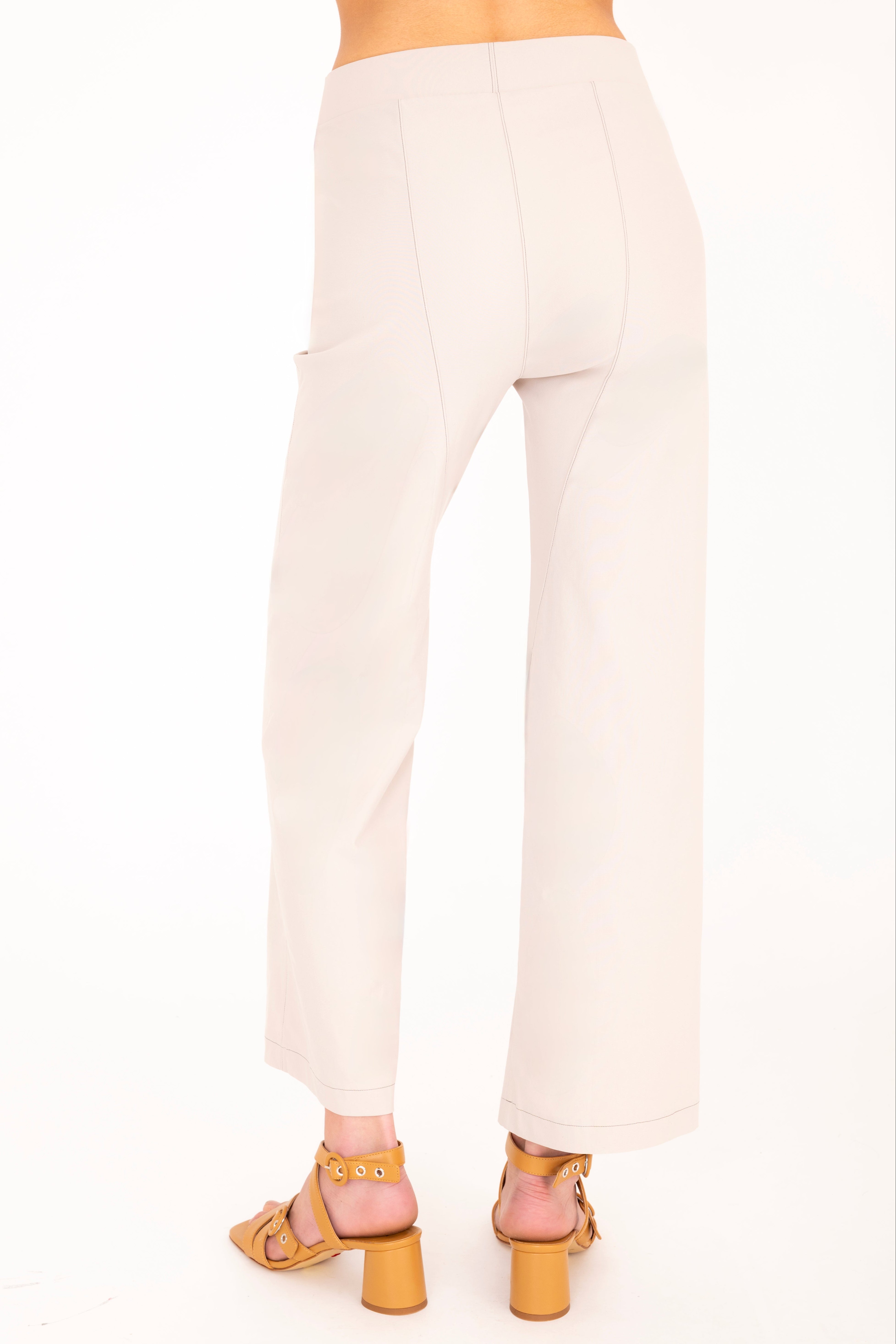 Beige pants worn by a person on a white background