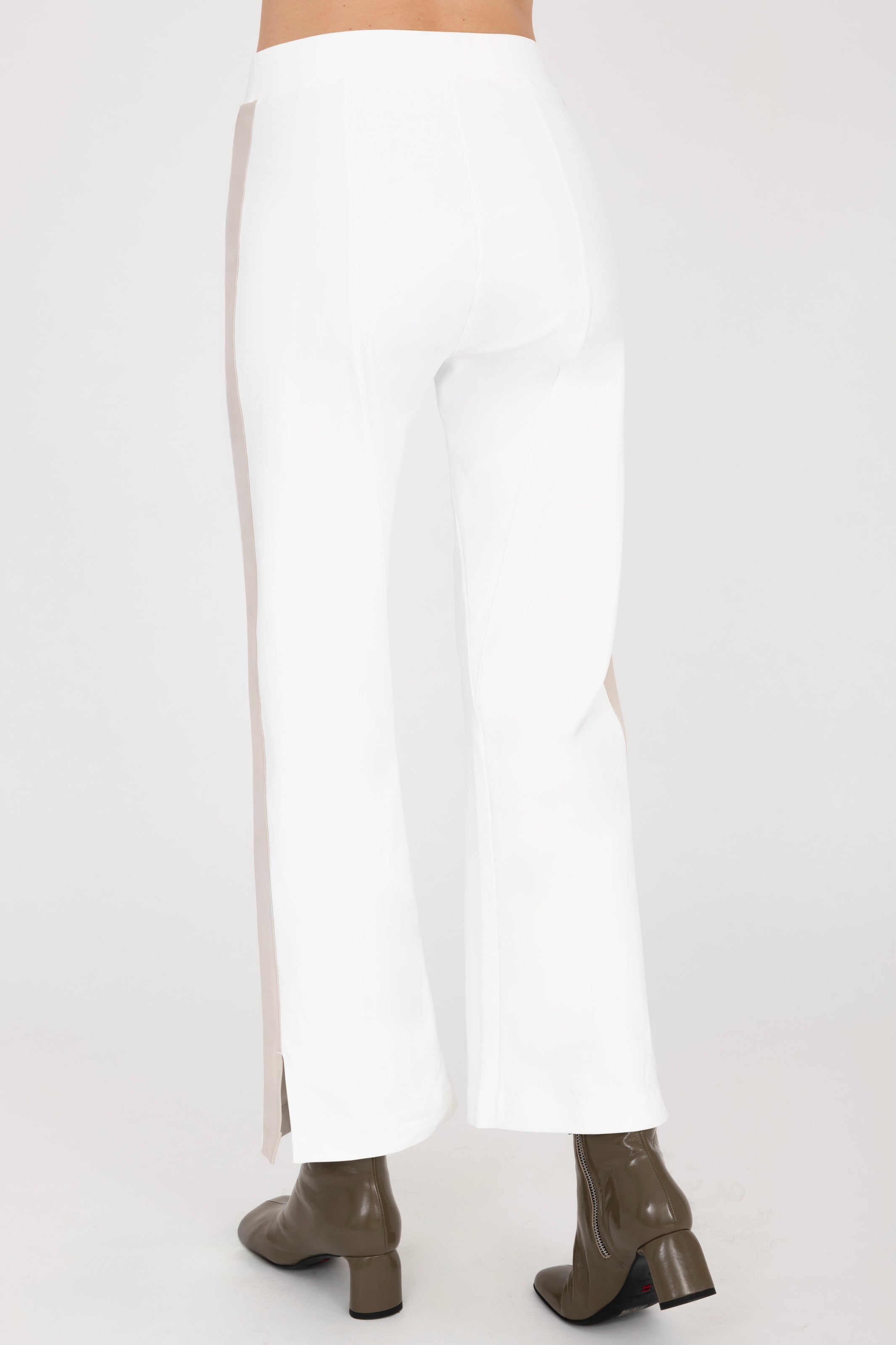 Back view of white cropped pants with beige side stripe on a white background
