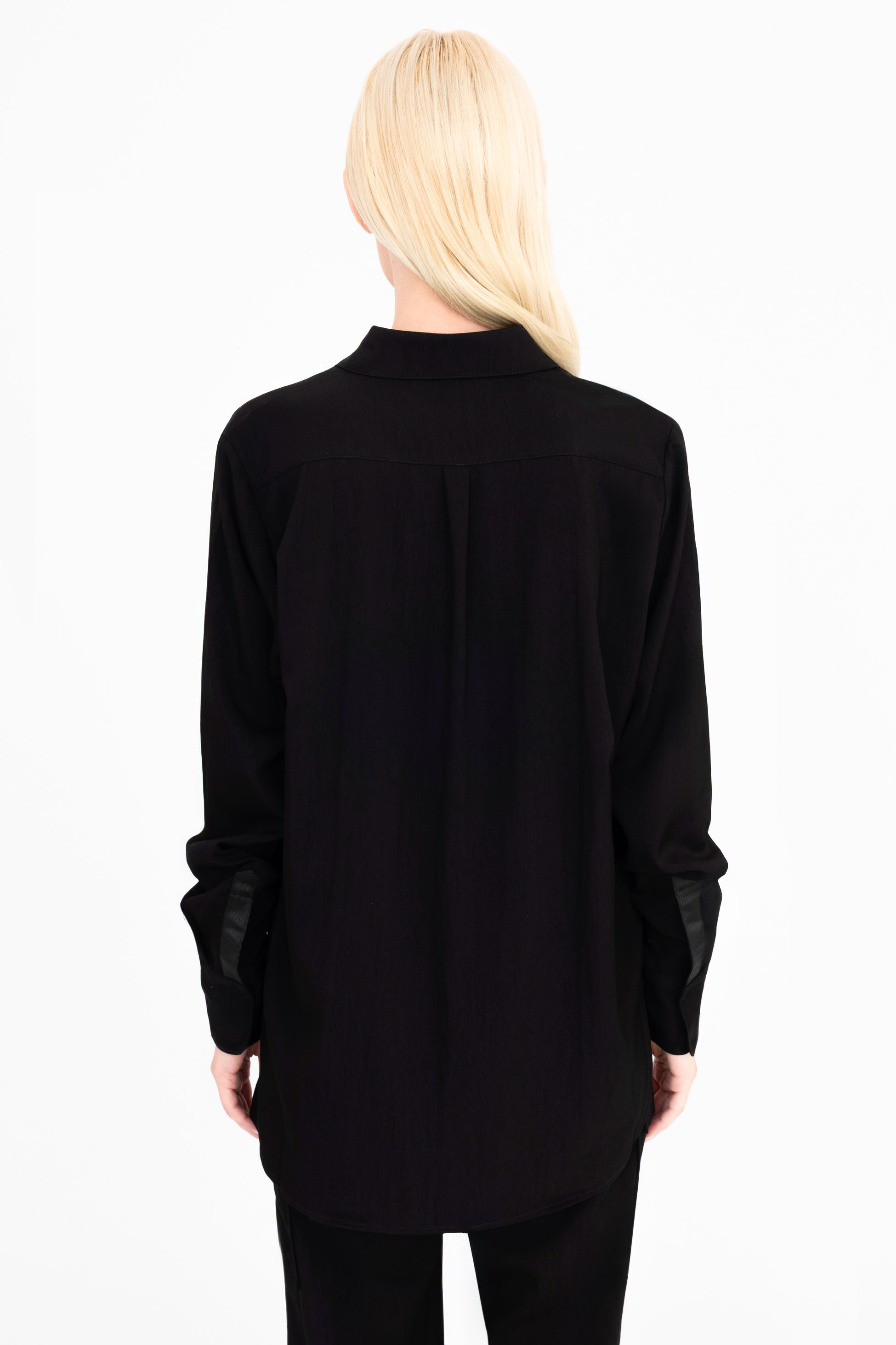Back view of woman wearing a black shirt and pants on a white background