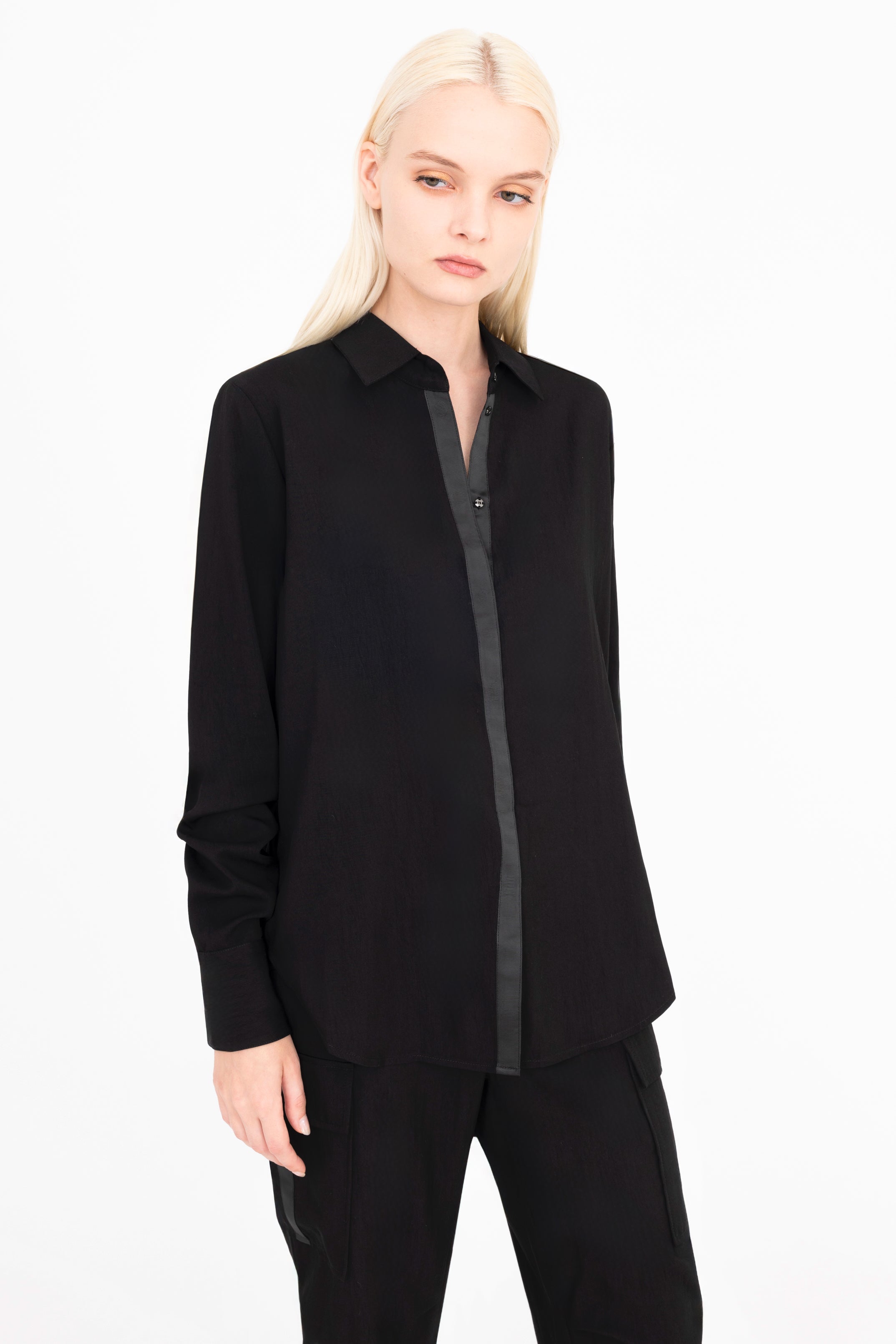 Quarter view of woman wearing a black shirt and pants on a white background
