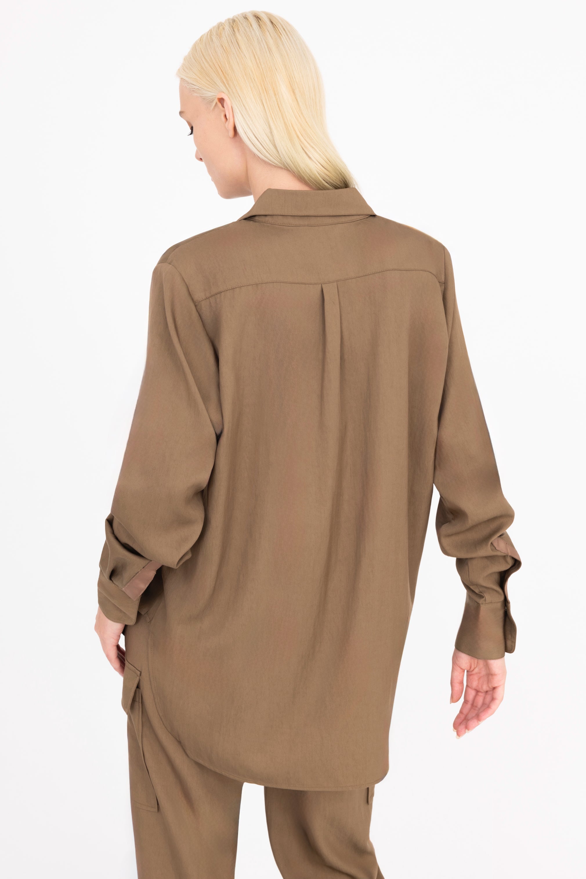 Back view of woman wearing a brown shirt and pants on a white background