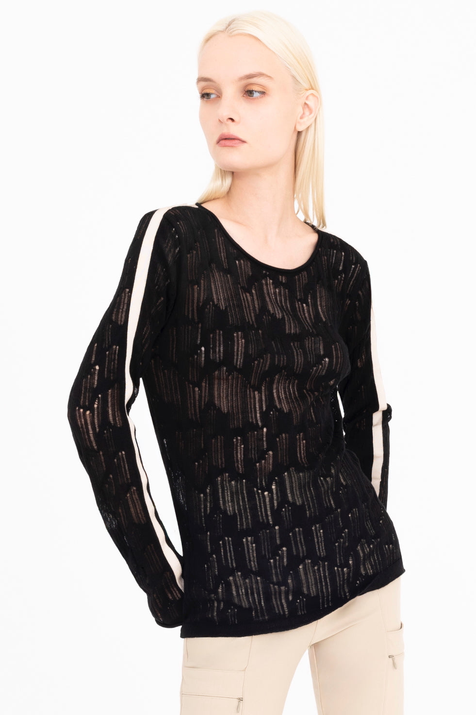 Woman wearing a black sheer long-sleeve top with white stripes on a white background