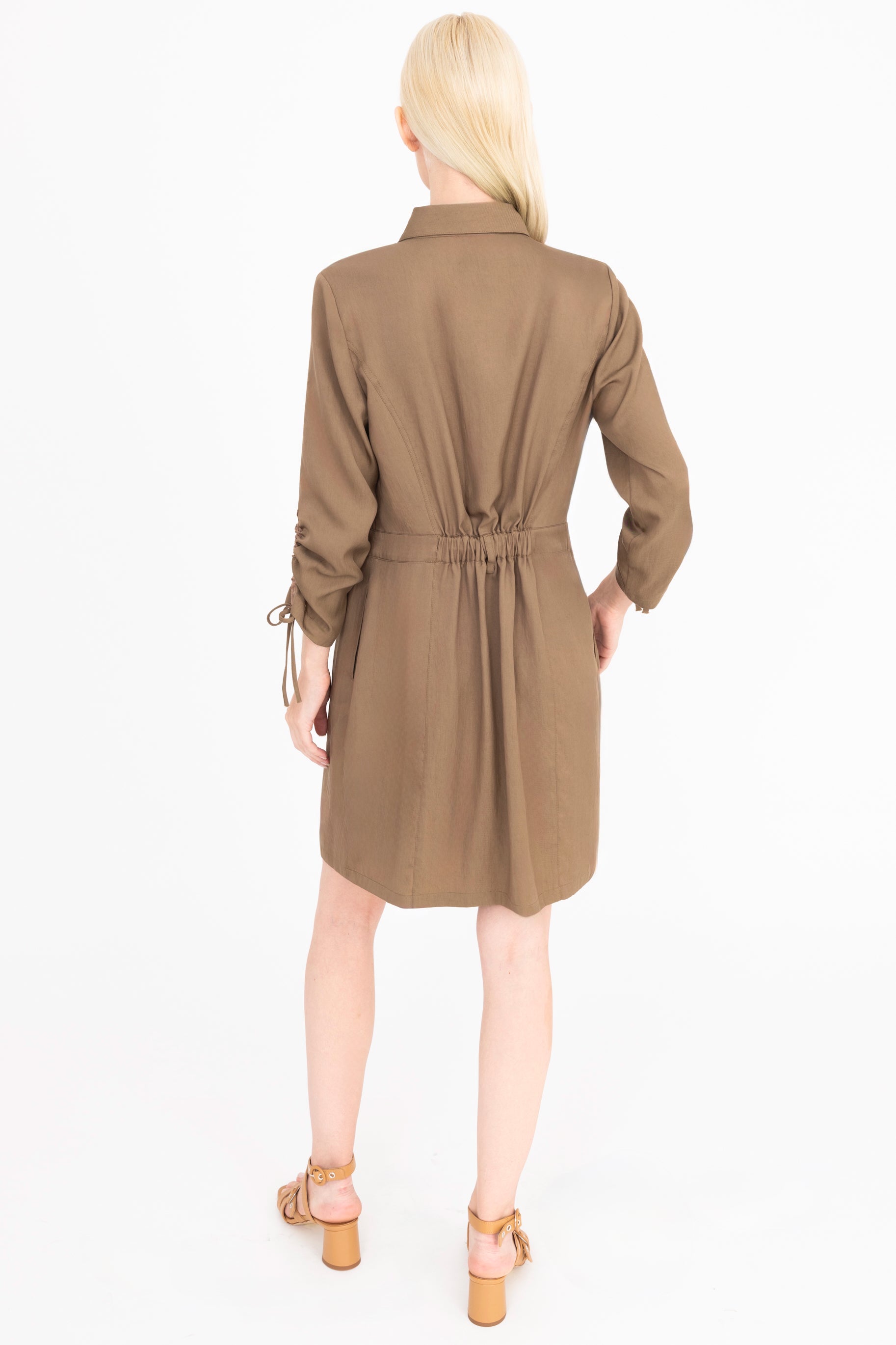 Back view of woman wearing a brown dress on a white background