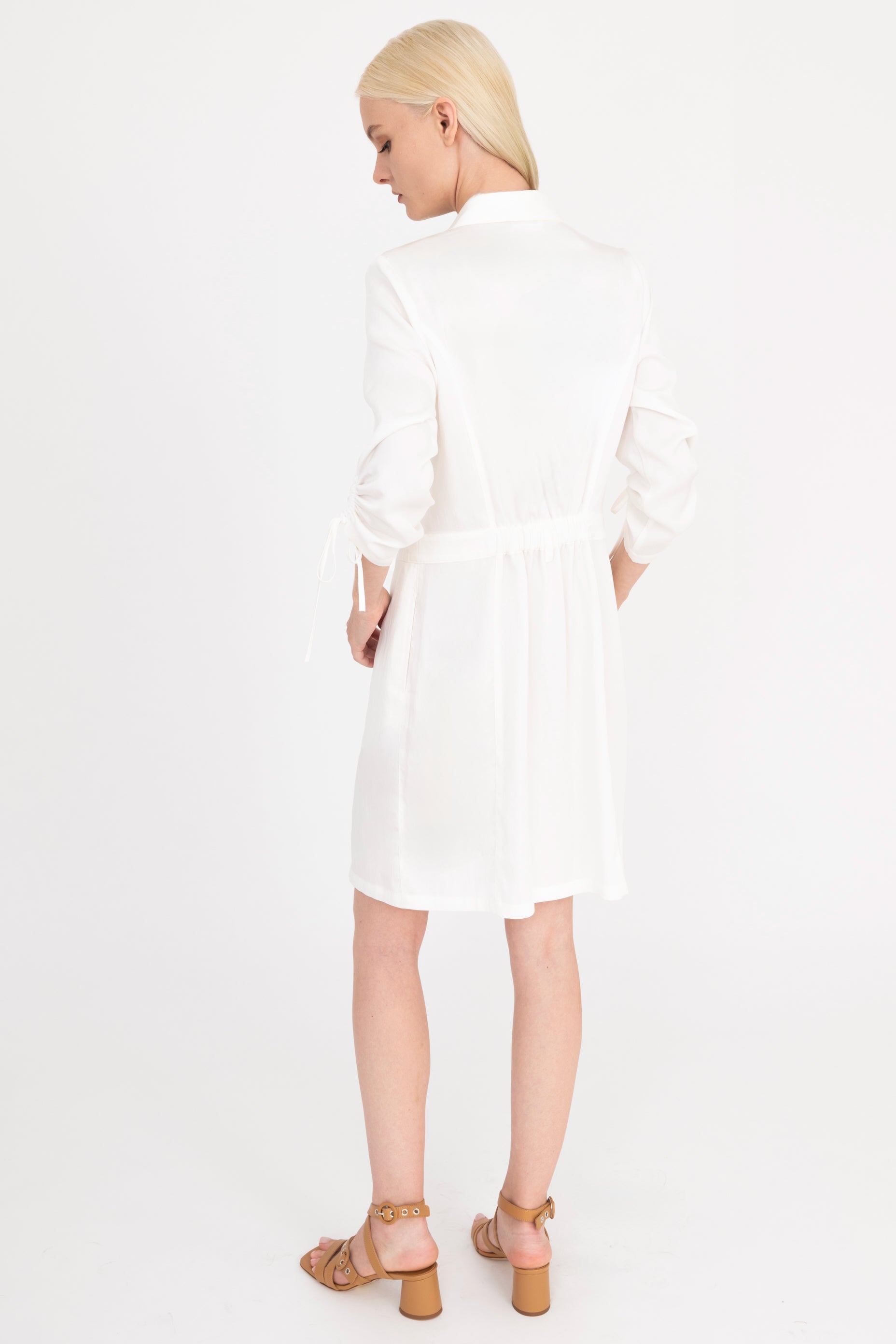 Back view of woman wearing a white dress on a white background