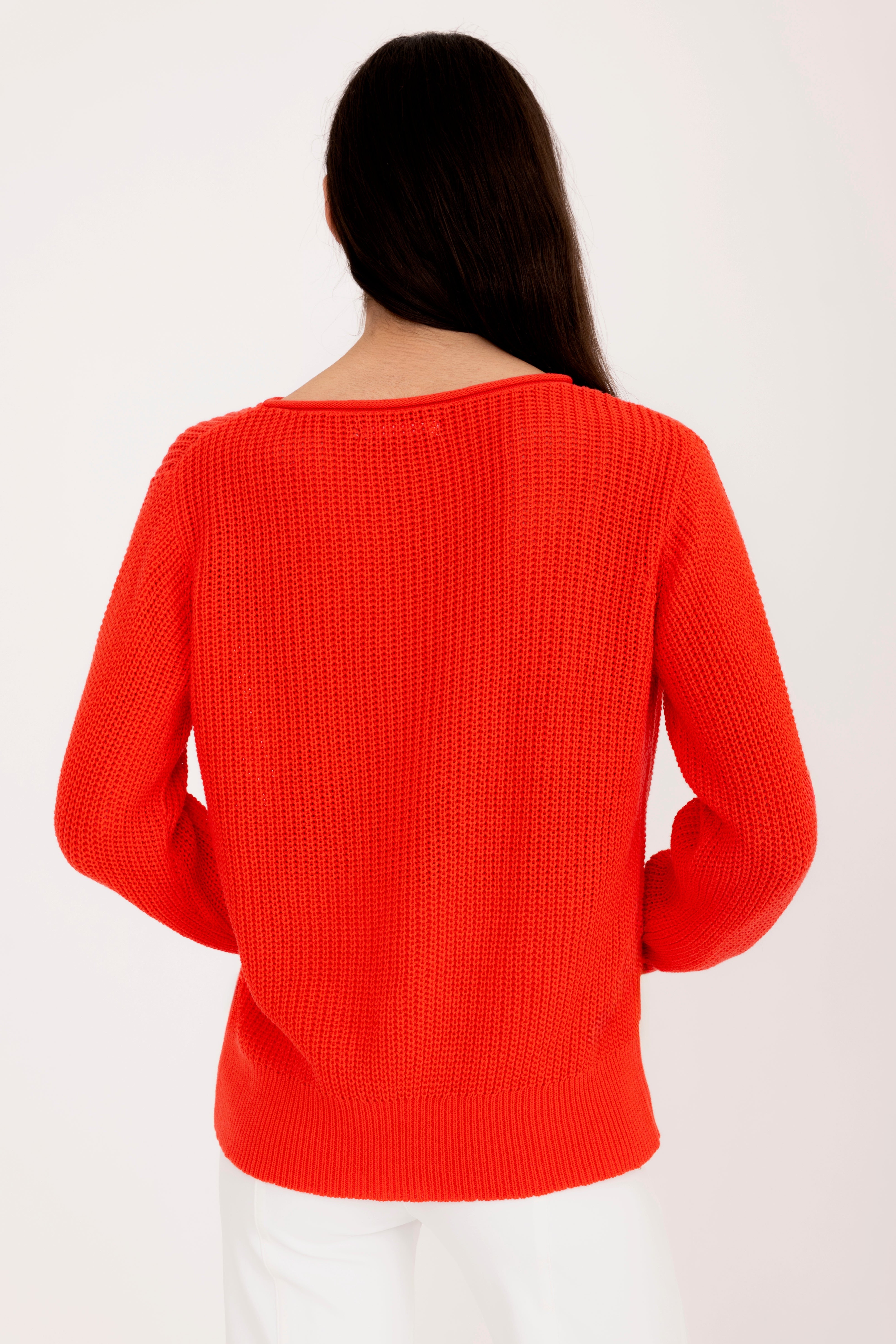 Woman wearing a orange sweater on a white background
