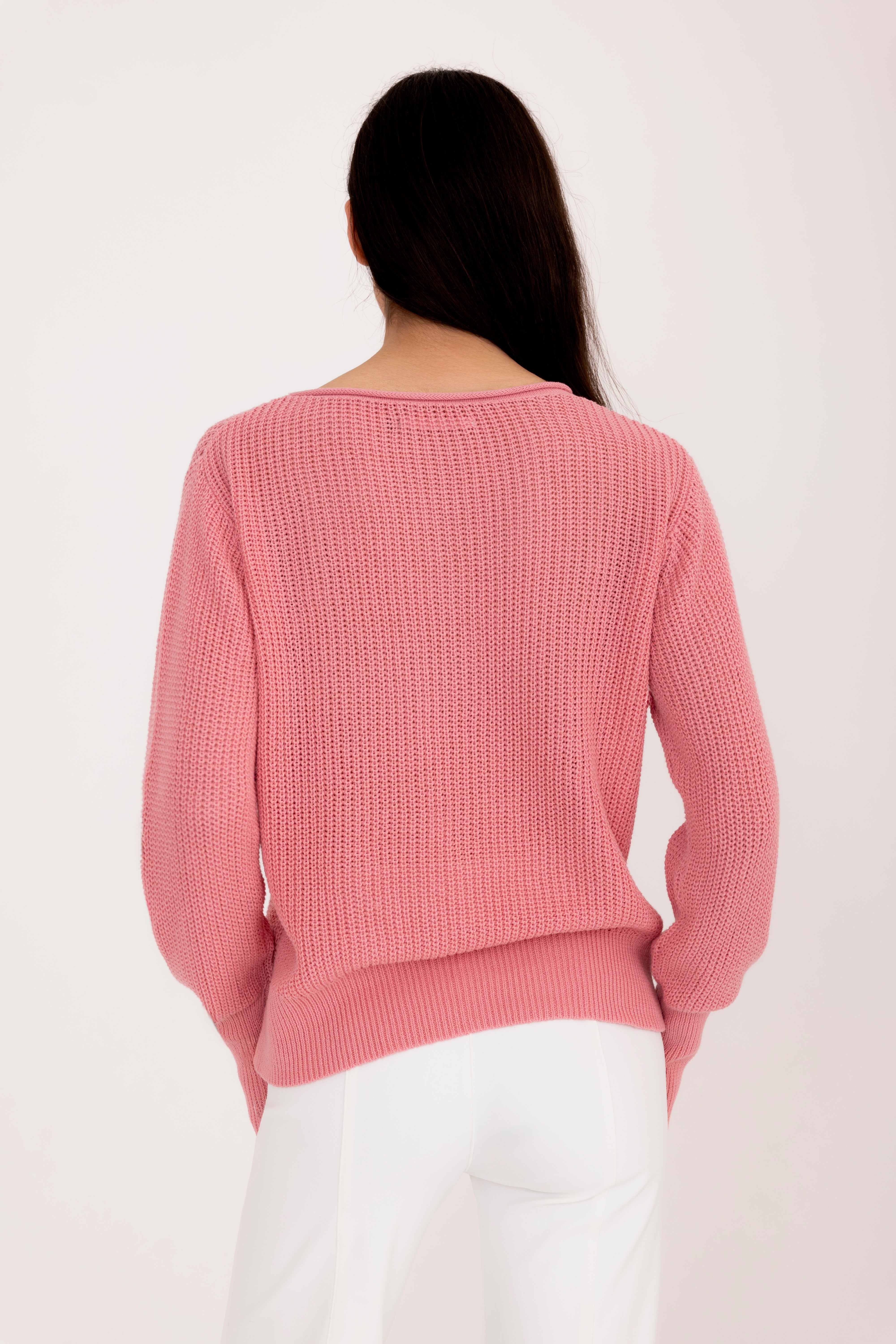 Woman wearing a pink sweater on a white background