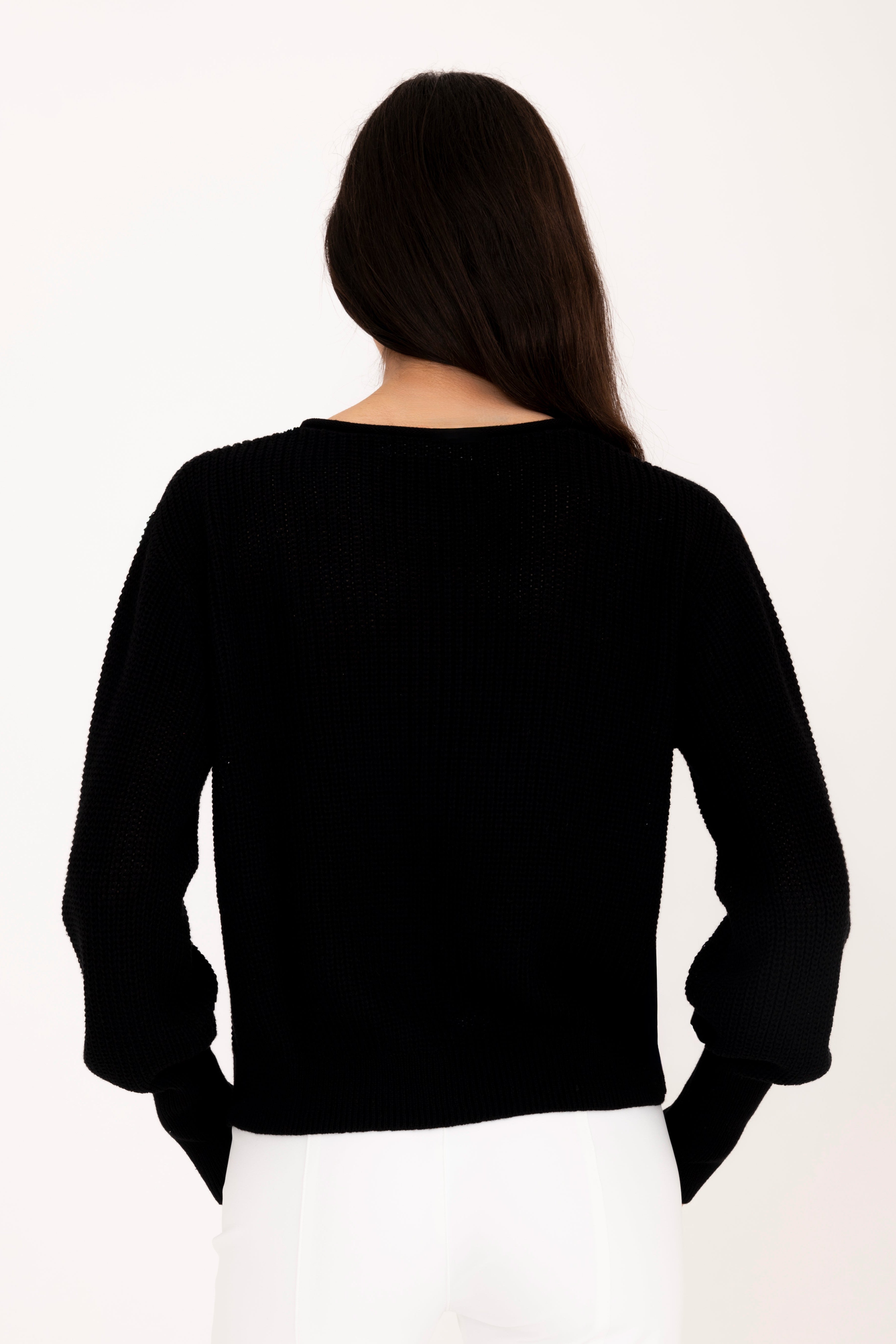 Person wearing a black long-sleeve top on a white background