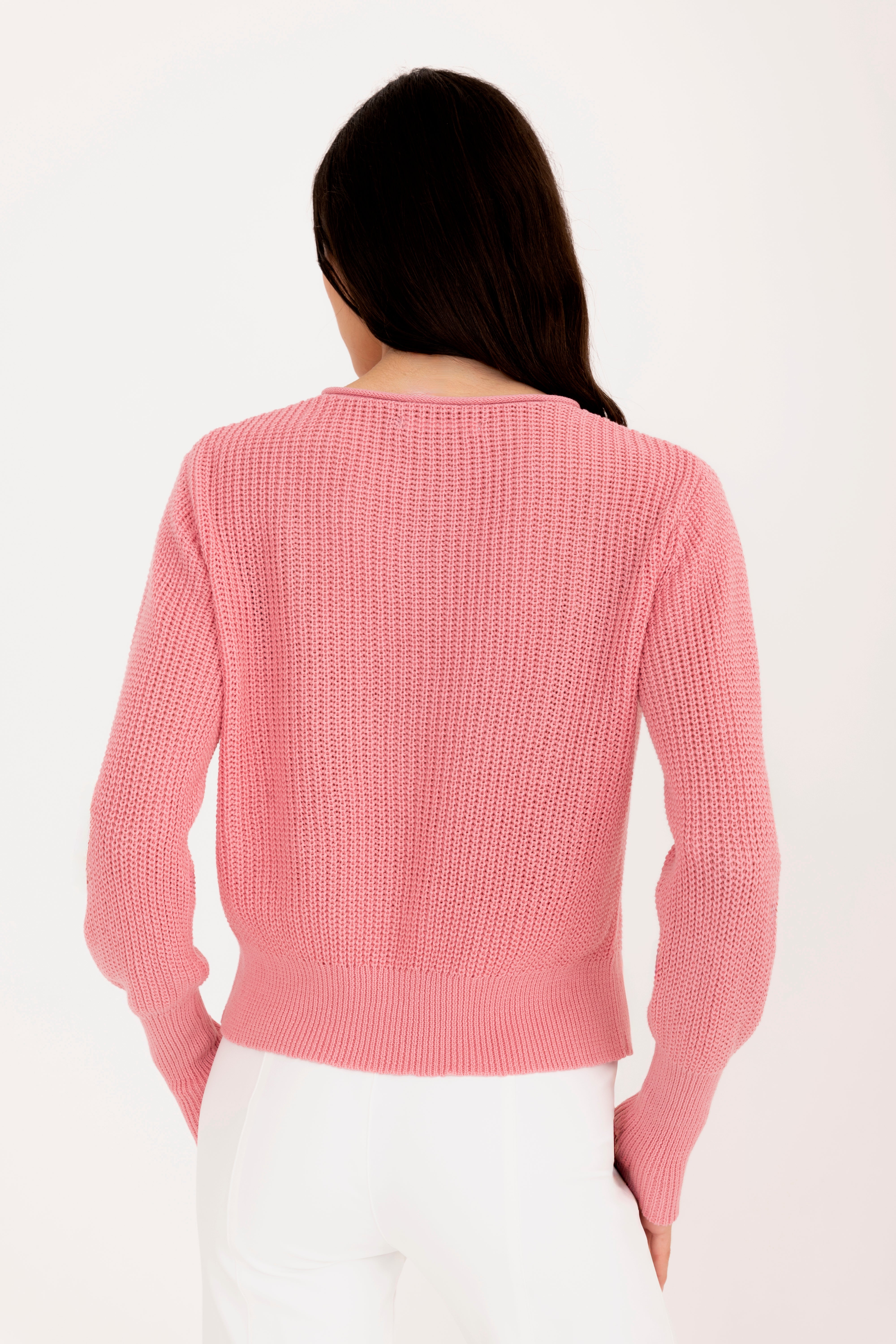 Person wearing a pink knitted sweater on a white background
