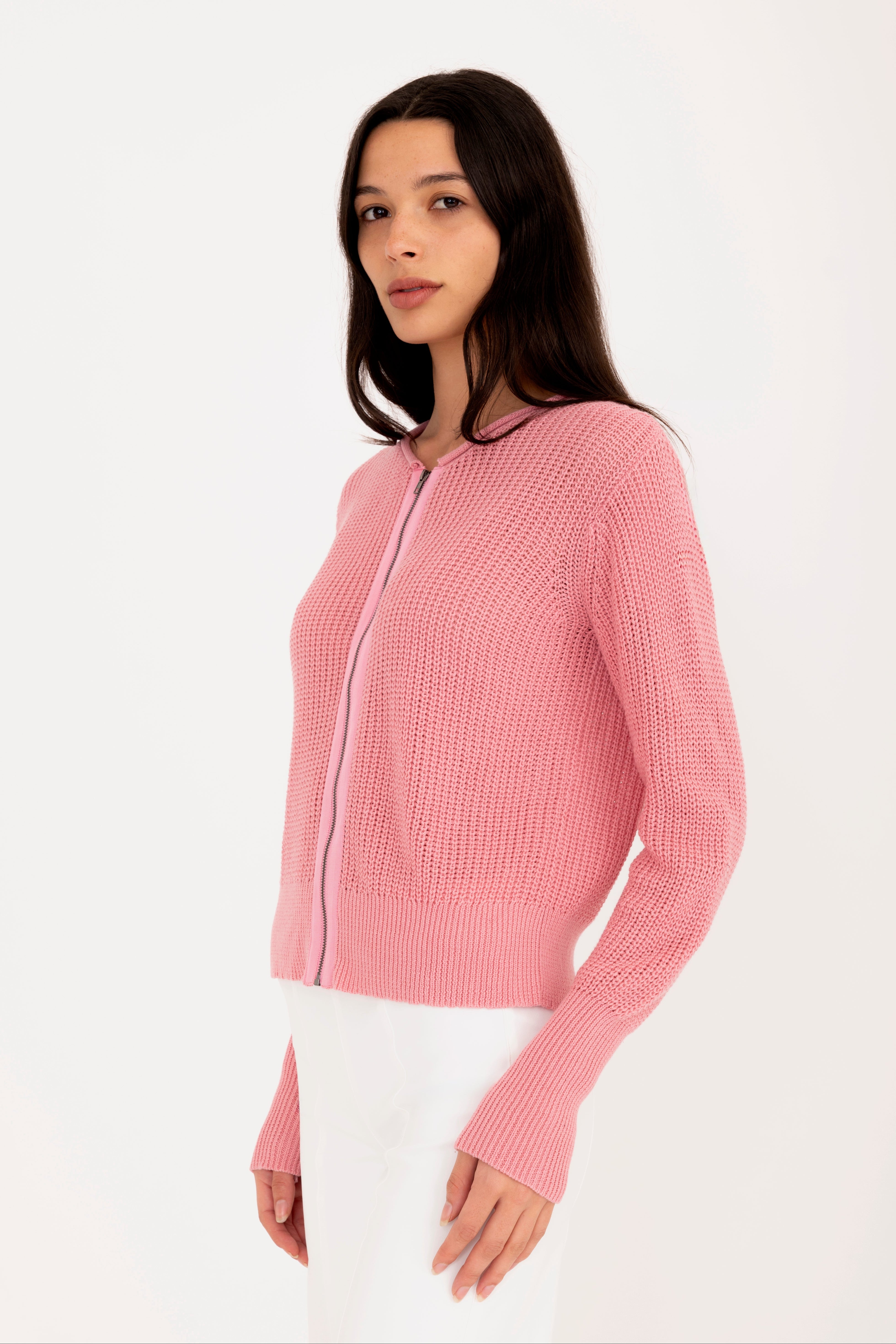 Woman wearing a pink zip-up cardigan on a white background