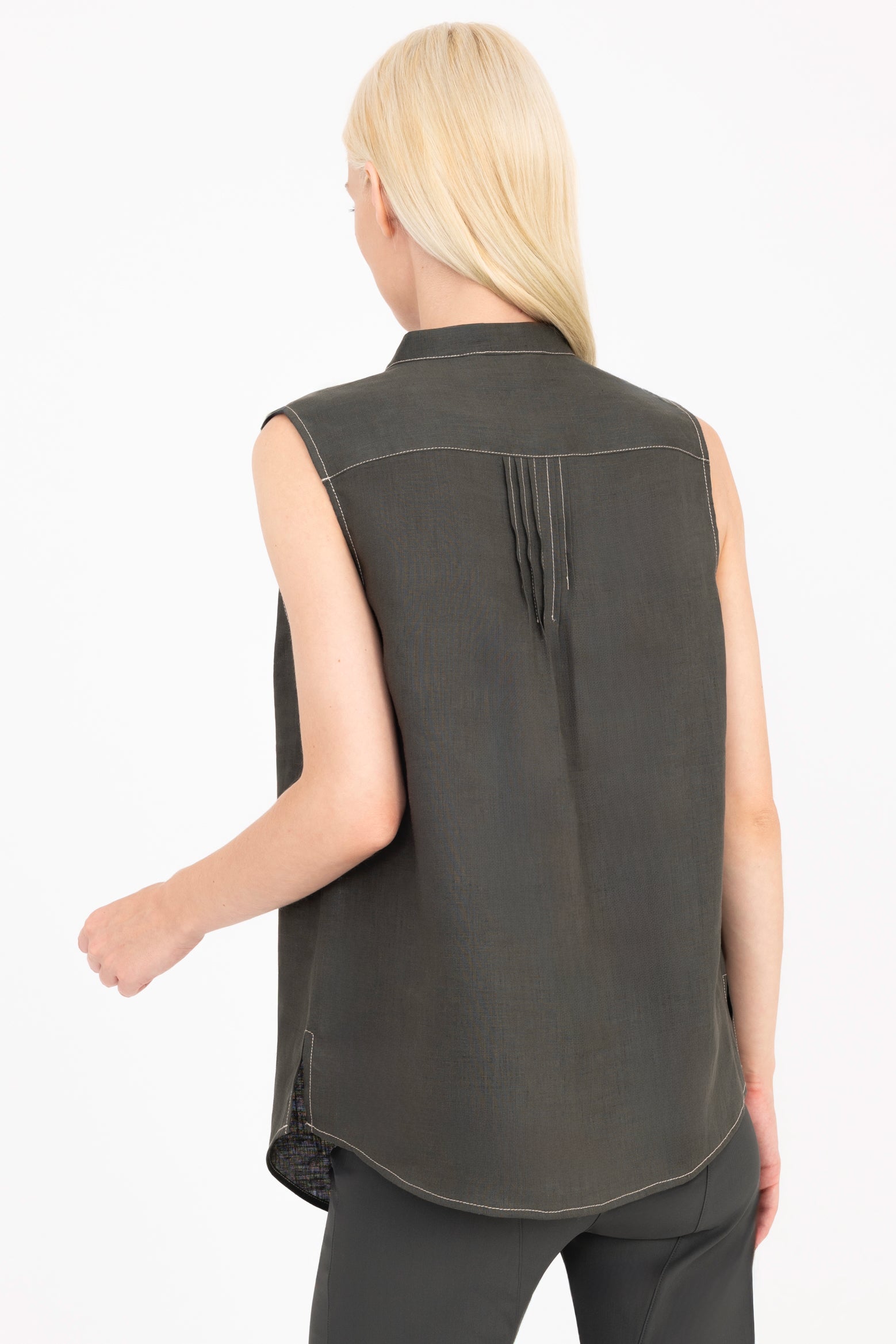 Woman wearing a sleeveless pine green shirt on a white background