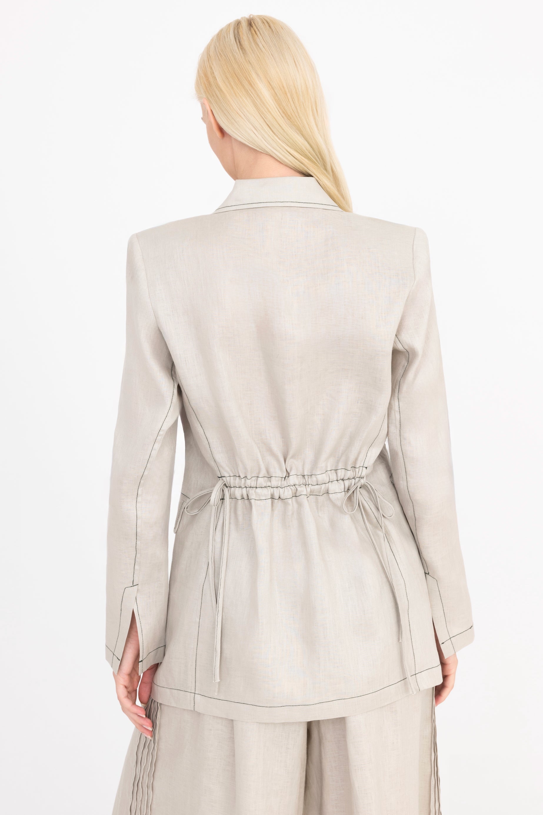 Woman wearing a light beige suit on a white background