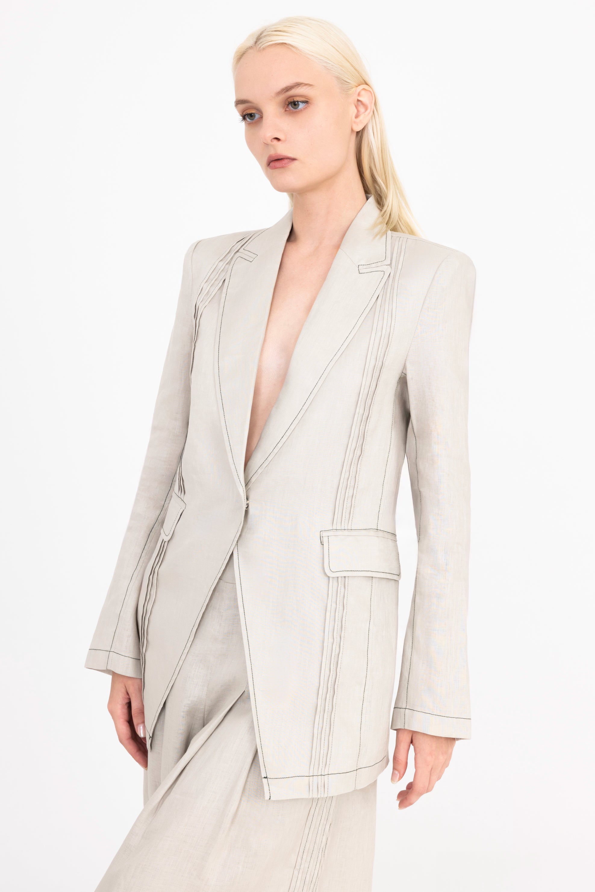Woman wearing a light beige suit on a white background