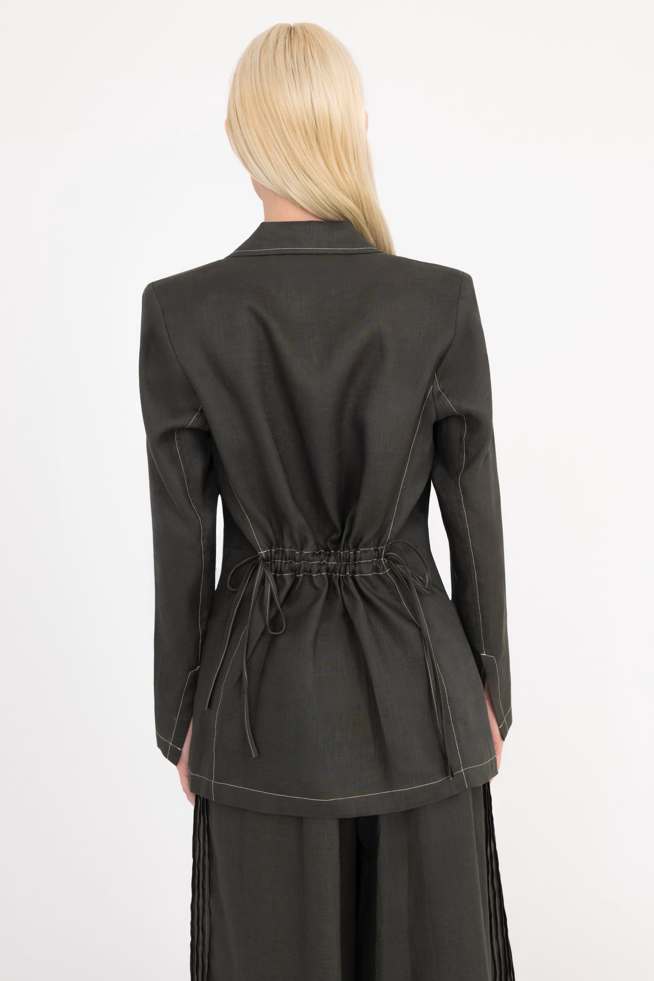 Woman wearing a pine green suit on a white background