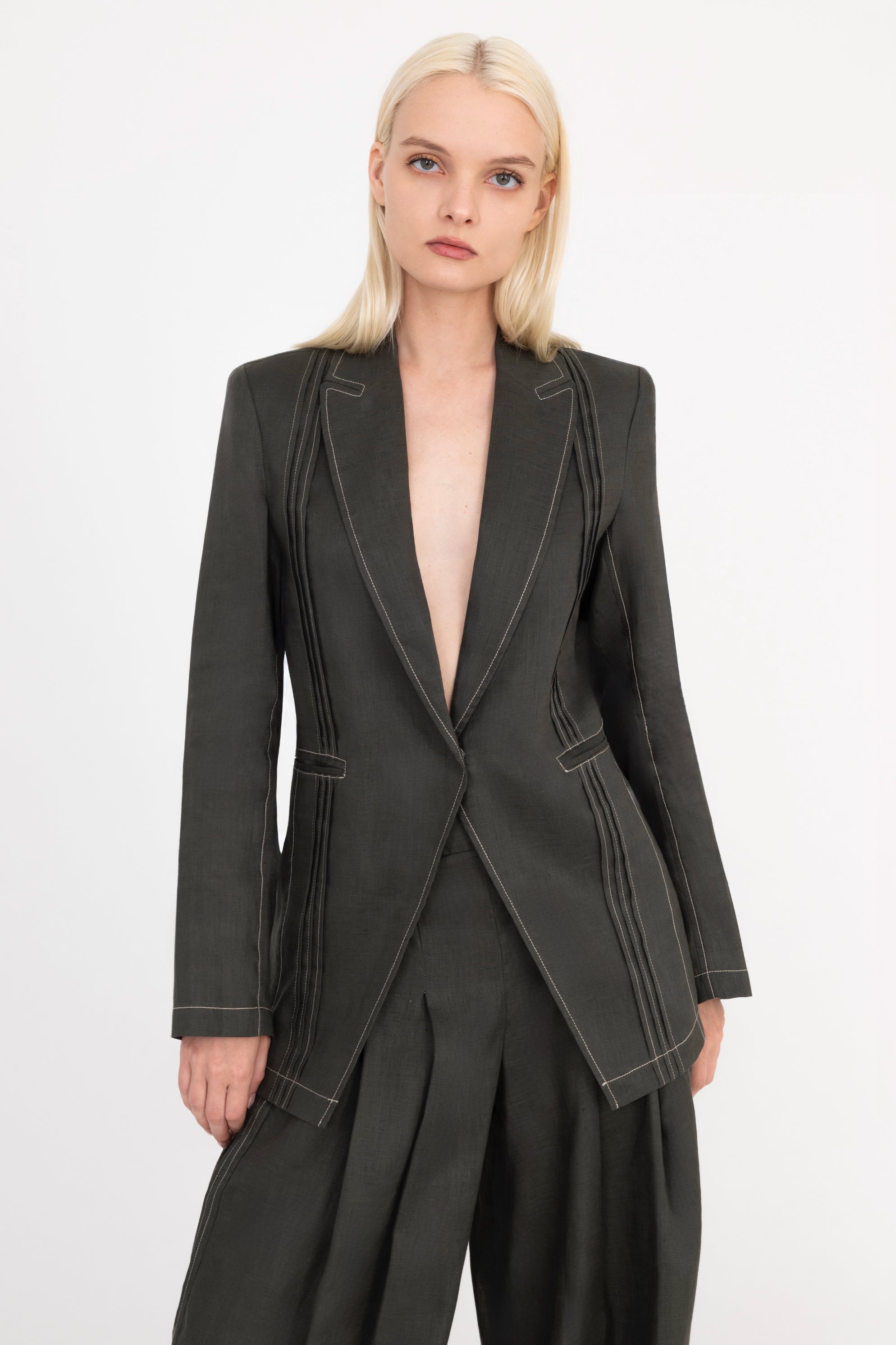 Woman wearing a pine green  suit on a white background