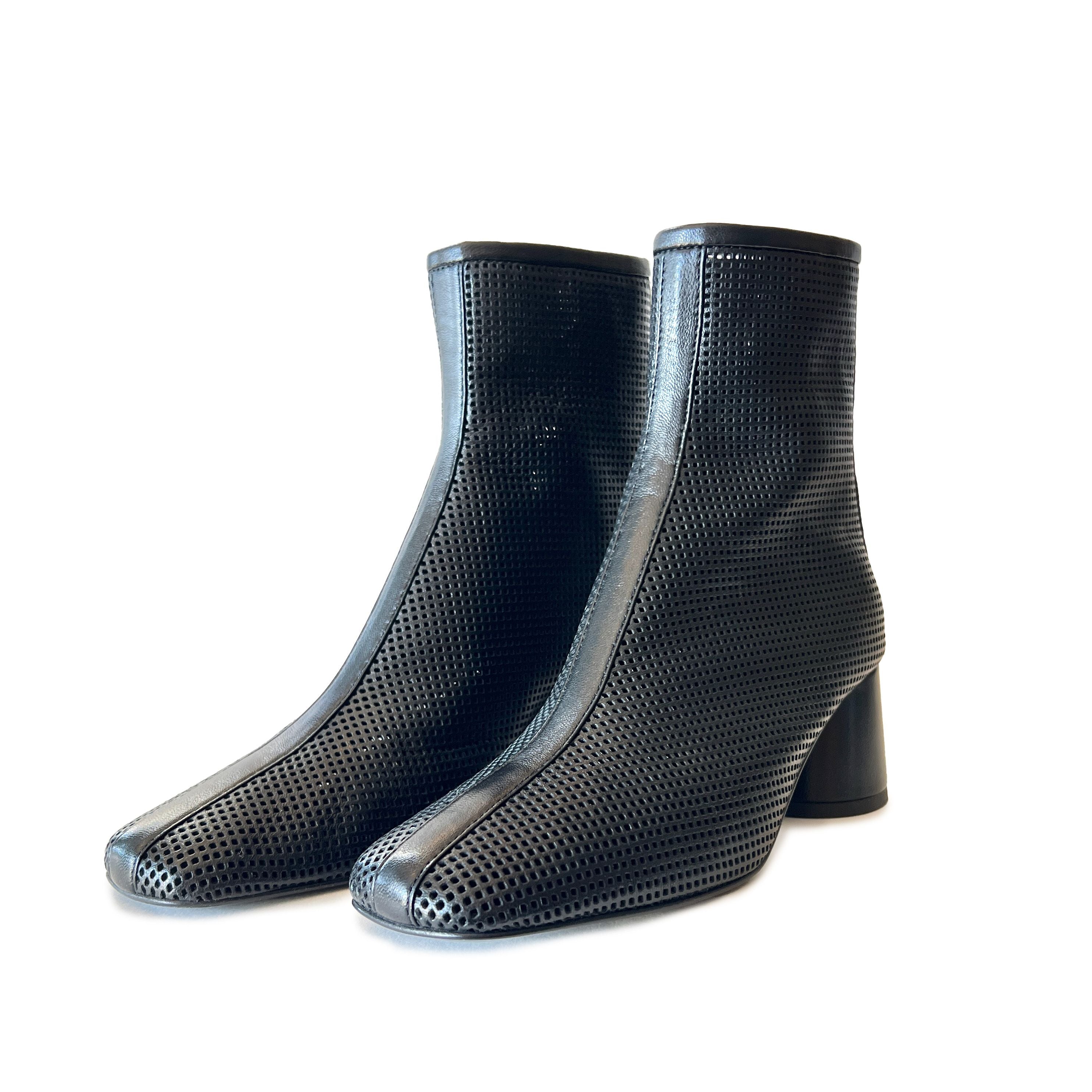Black round toe perforated ankle boots on a white background