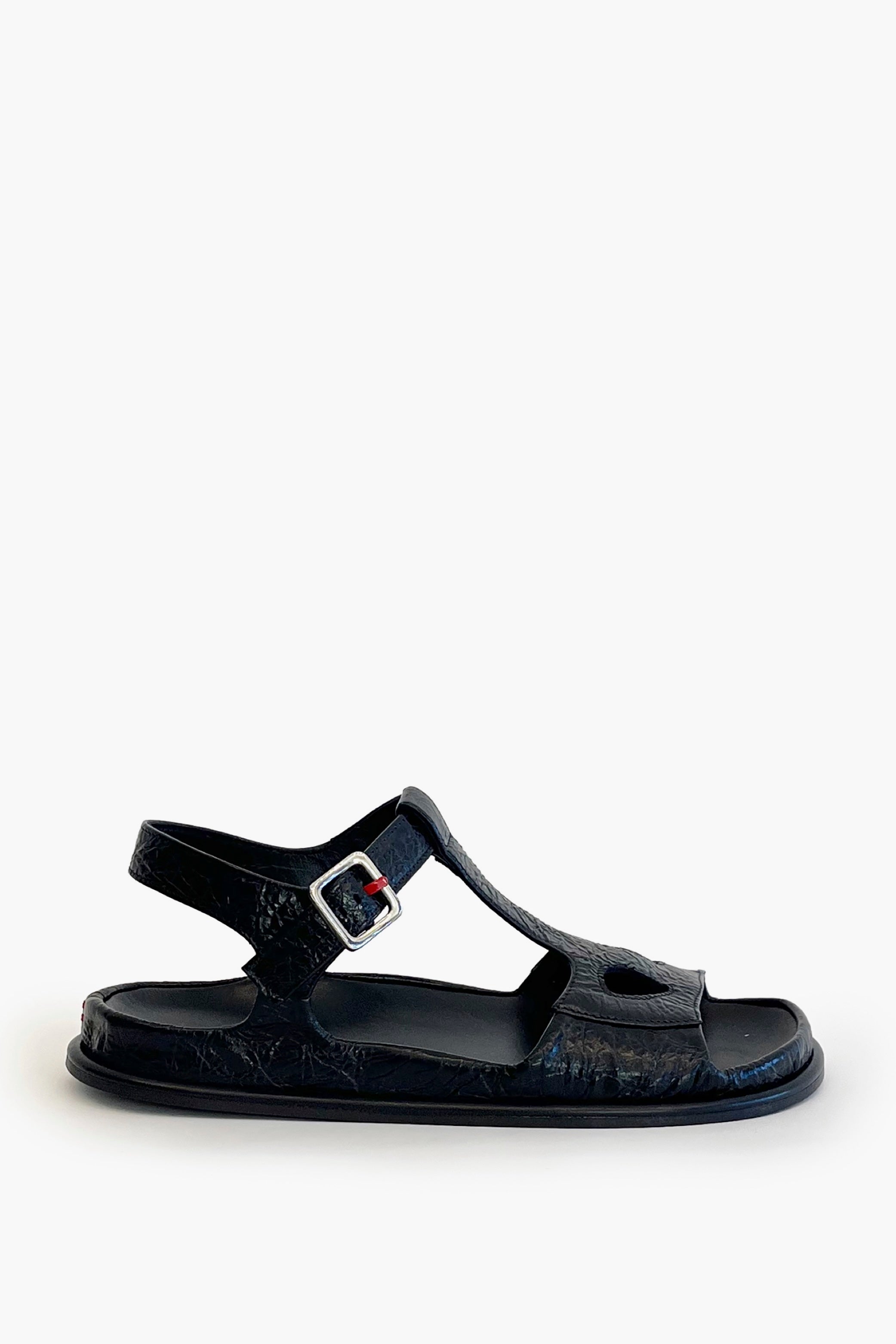 Black ankle strap flat sandal on a white background