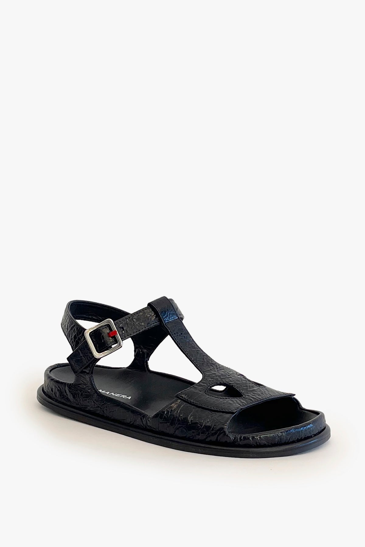Black ankle strap flat sandal on a white background