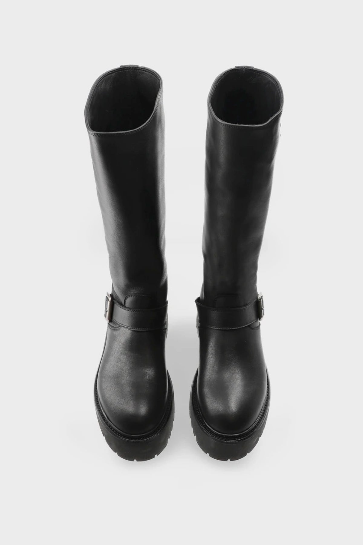 A pair of black leather knee-high boots with platform soles and a buckle strap detail on the side, shown from a top-down view on a light gray background.